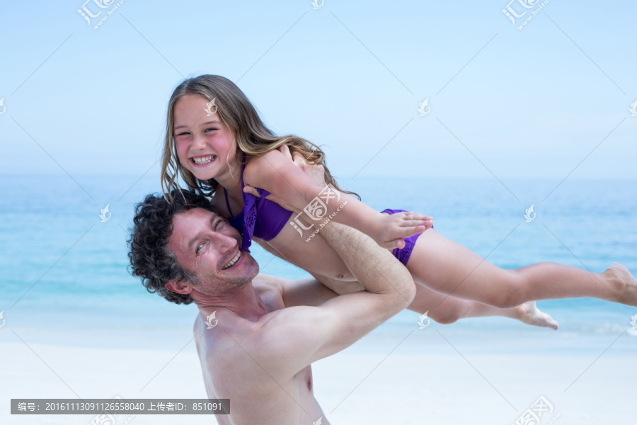在海边抱起女儿的父亲