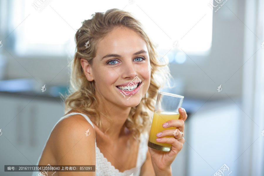 在厨房里喝一杯果汁的女人