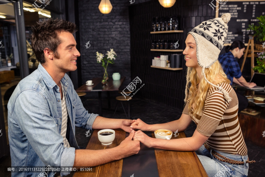 在咖啡馆里手拉着手的夫妇