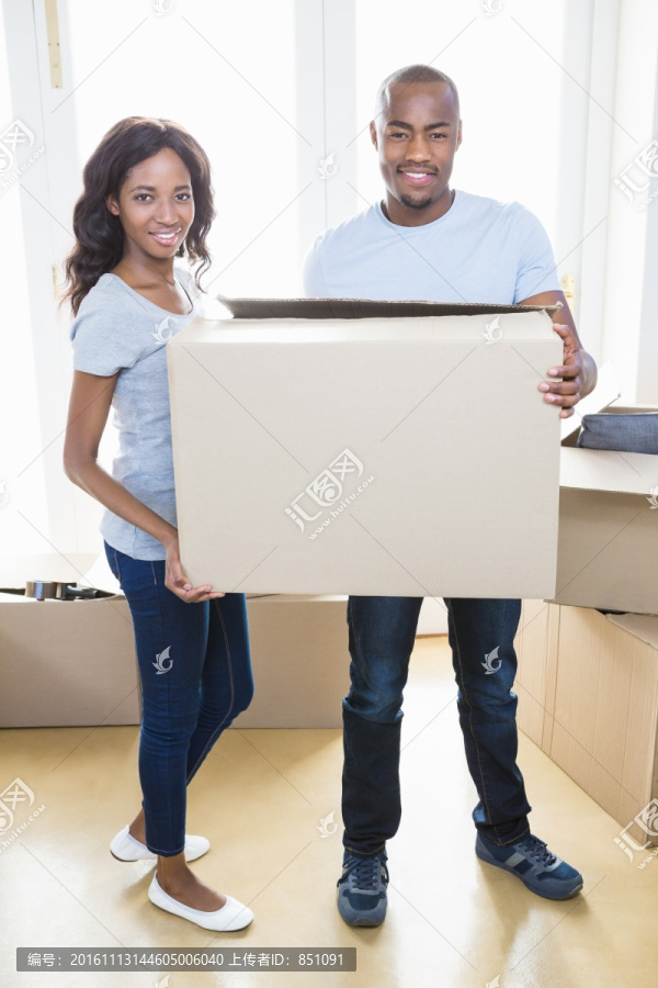 年轻夫妇抱着纸板箱