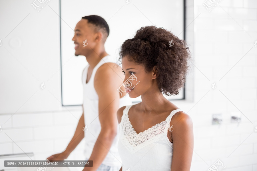 在浴室里照镜子的夫妇