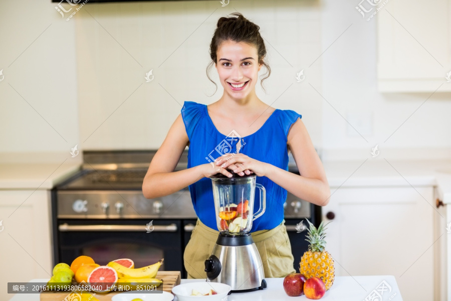 年轻女子在厨房里榨果汁