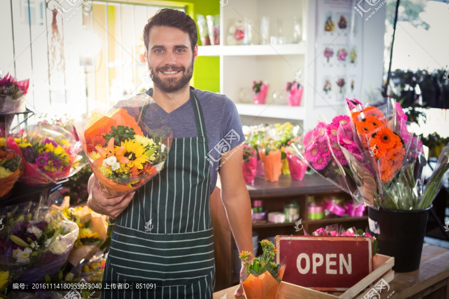 拿着花束的男员工在花店里