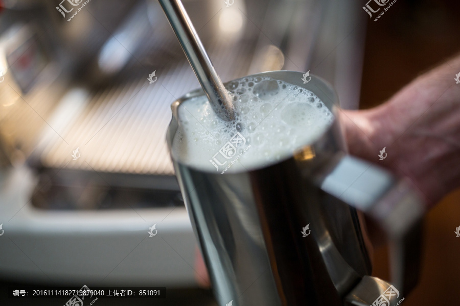 餐厅服务员在咖啡机上蒸牛奶