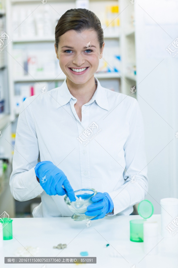 在药房里捣碎药材的女药剂师