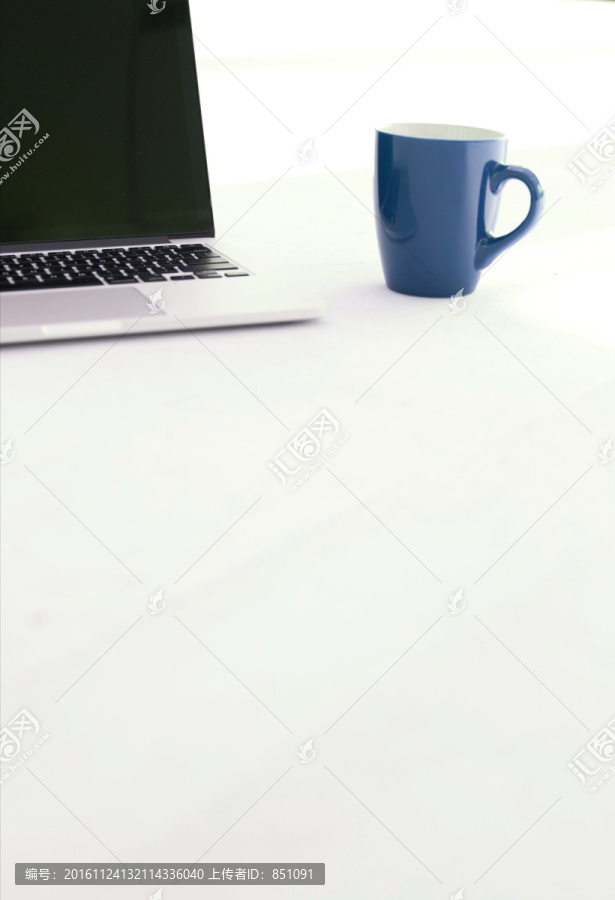 地上的杯子与笔记本电脑