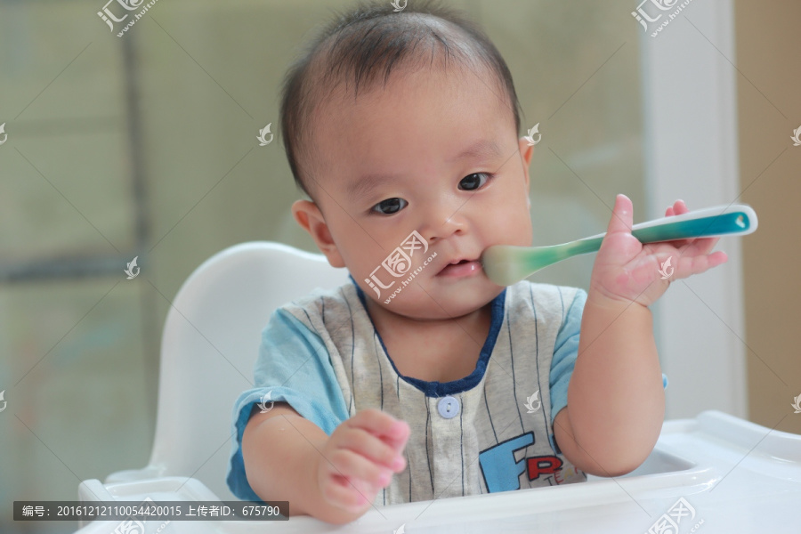 亚洲小婴儿抓着勺子放嘴里啃咬