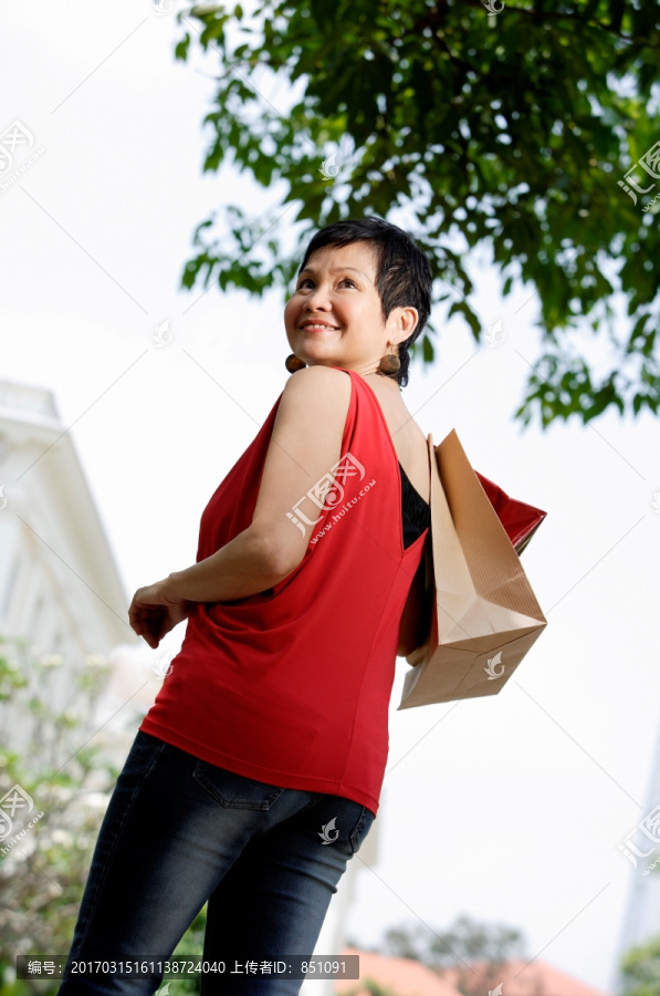微笑着拿着购物袋的女人