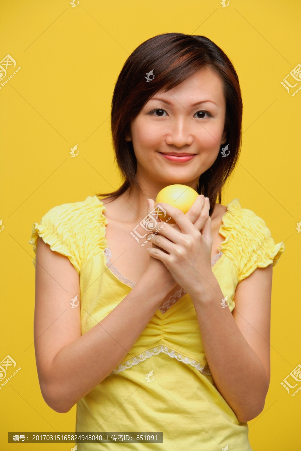 年轻女子手持柠檬