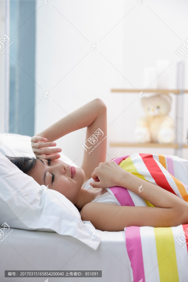 年轻女子躺在床上揉着眼睛