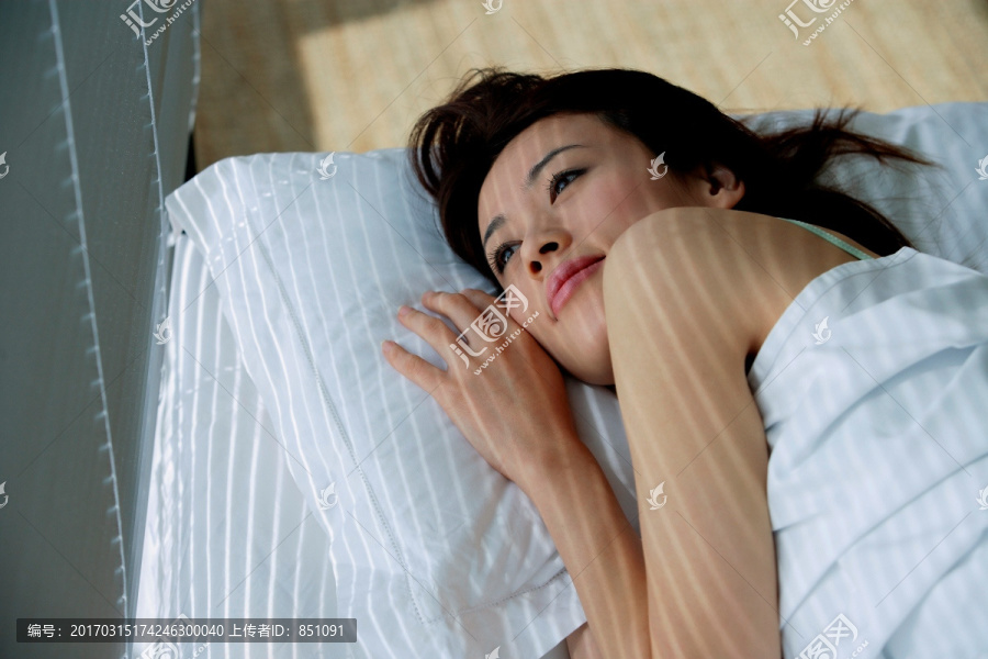 一个女人躺在床上望着窗外