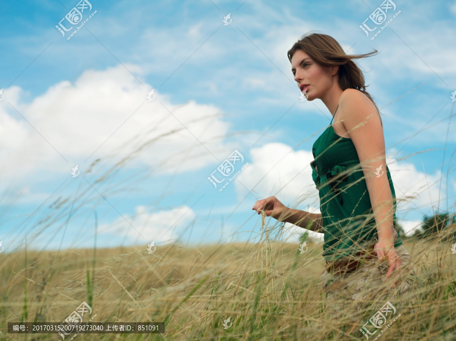 在草地上散步的年轻女子