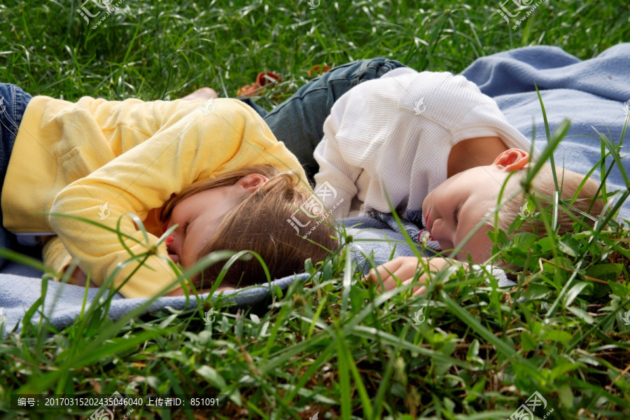 兄妹躺在公园的毯子上