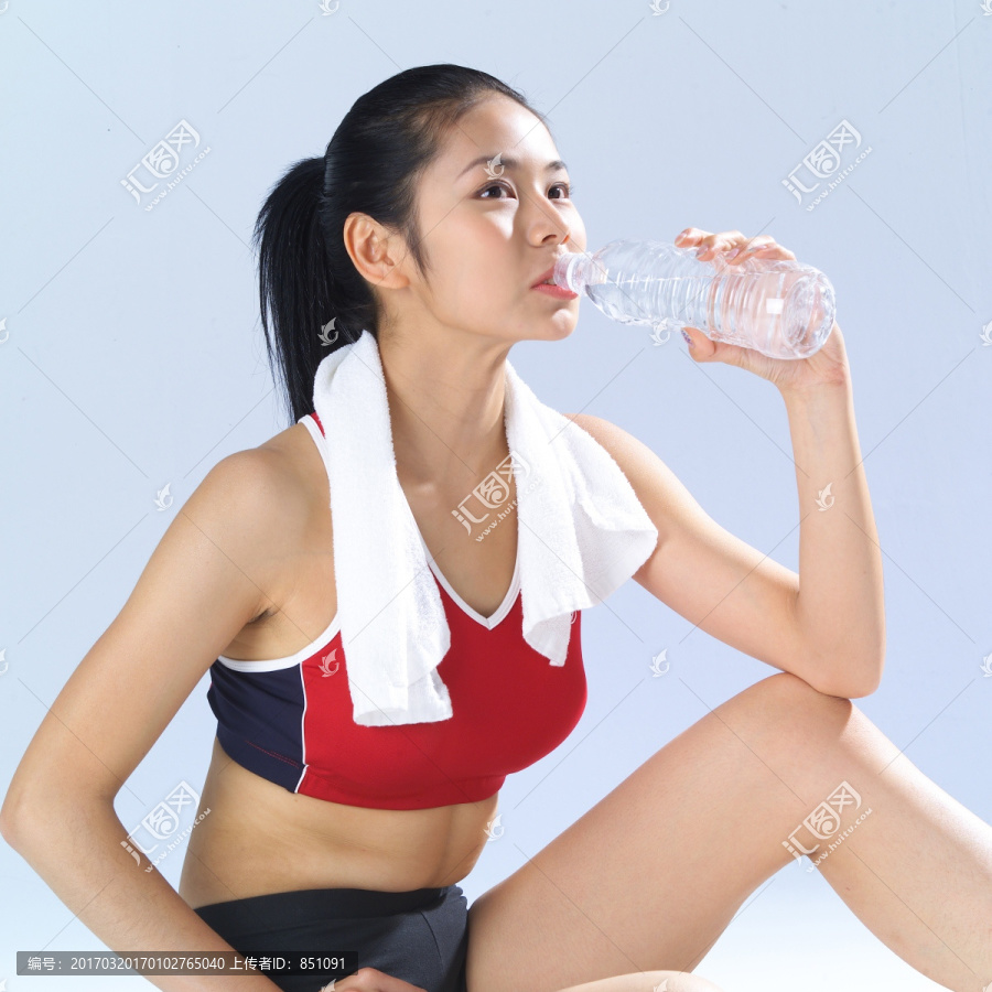 手叉腰喝水的女人