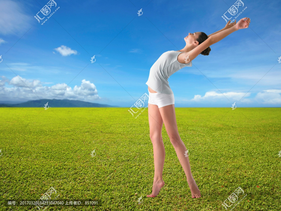 站在草坪上伸展手臂的女人