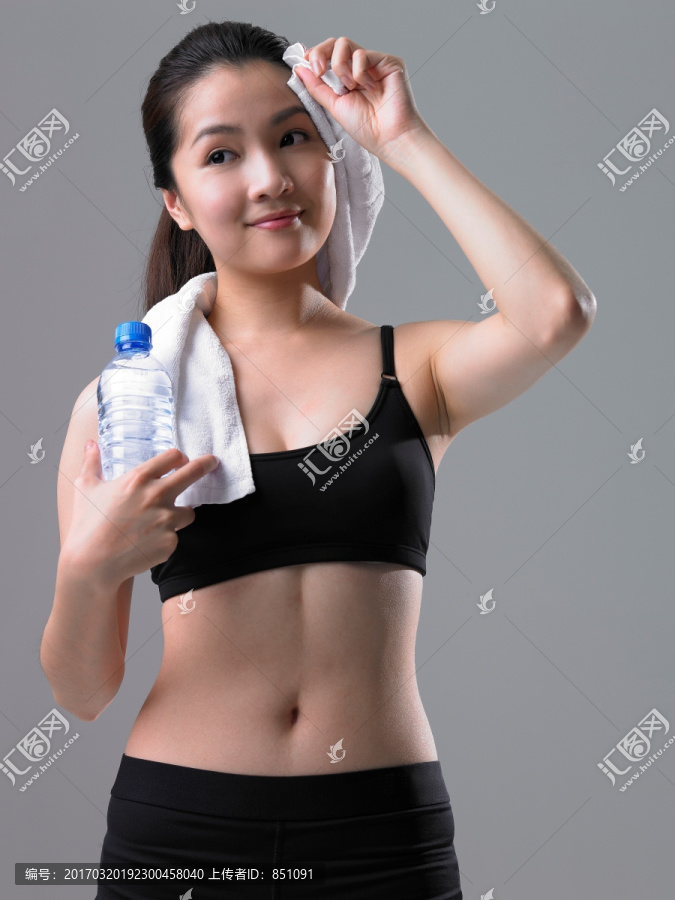 微笑着拿着水瓶的健身女人