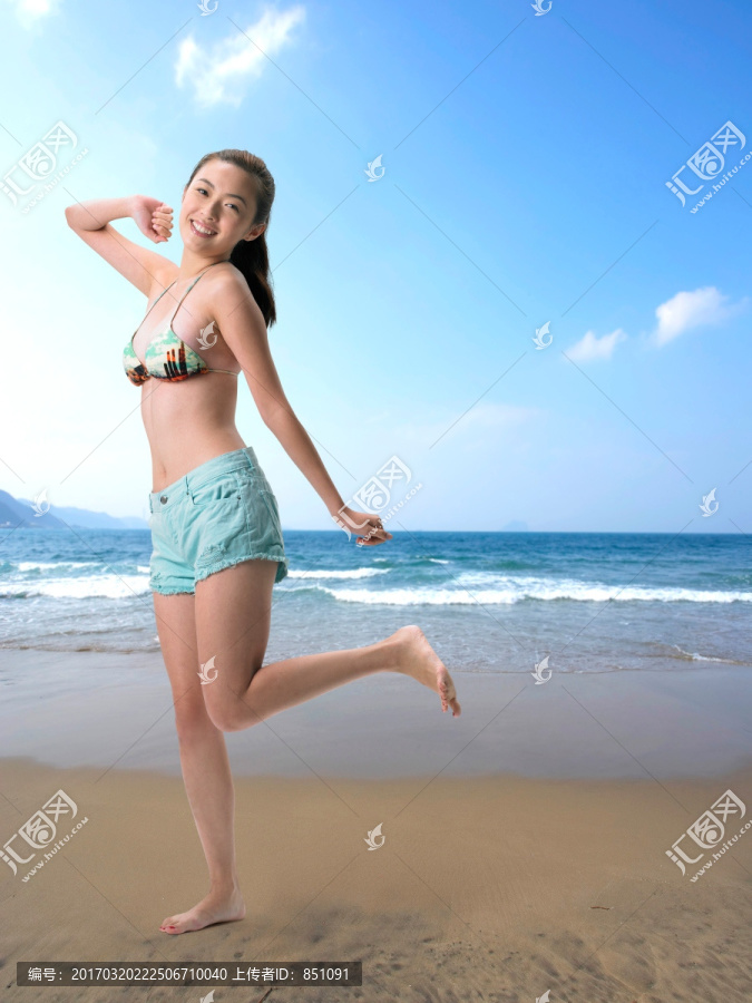 穿着比基尼站在海滩上的女人
