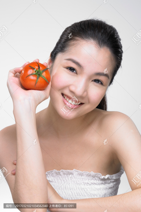 拿着西红柿微笑着的女人