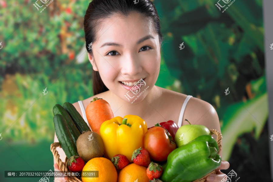 女人微笑着拿着水果