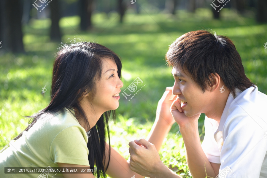 趴在草坪上互相看着彼此的夫妇