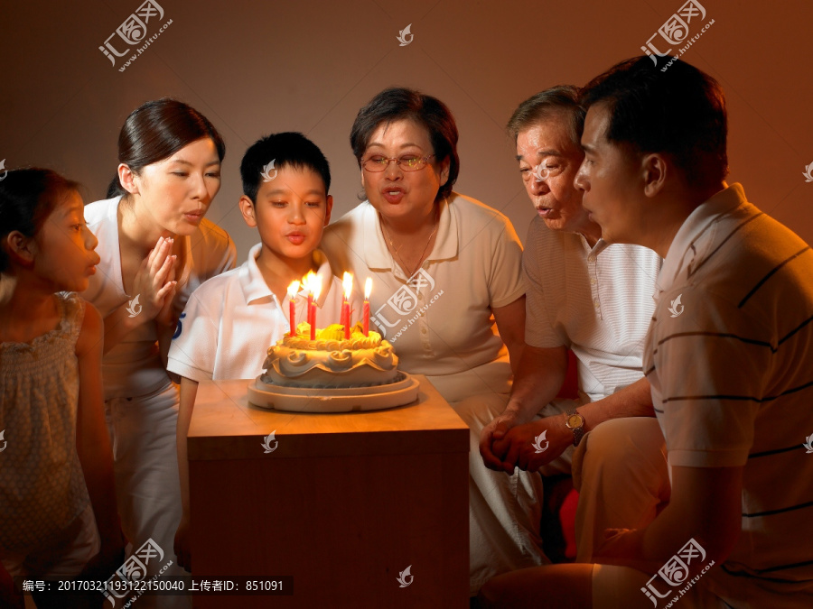 在庆祝生日吹蛋糕的家人