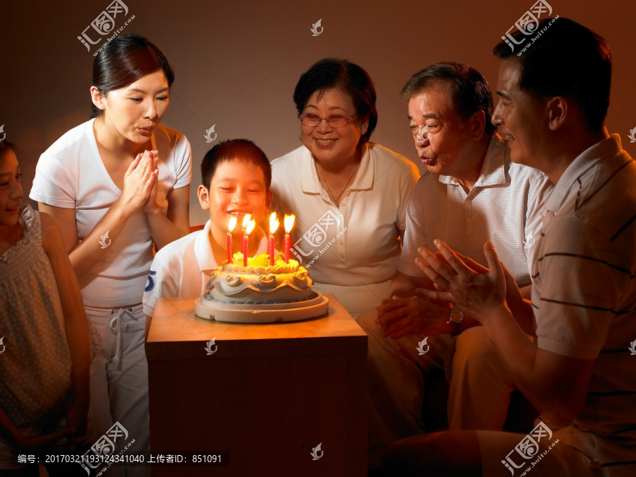 在庆祝生日吹蛋糕的家人