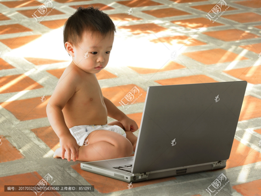 看着笔记本电脑屏幕的婴儿