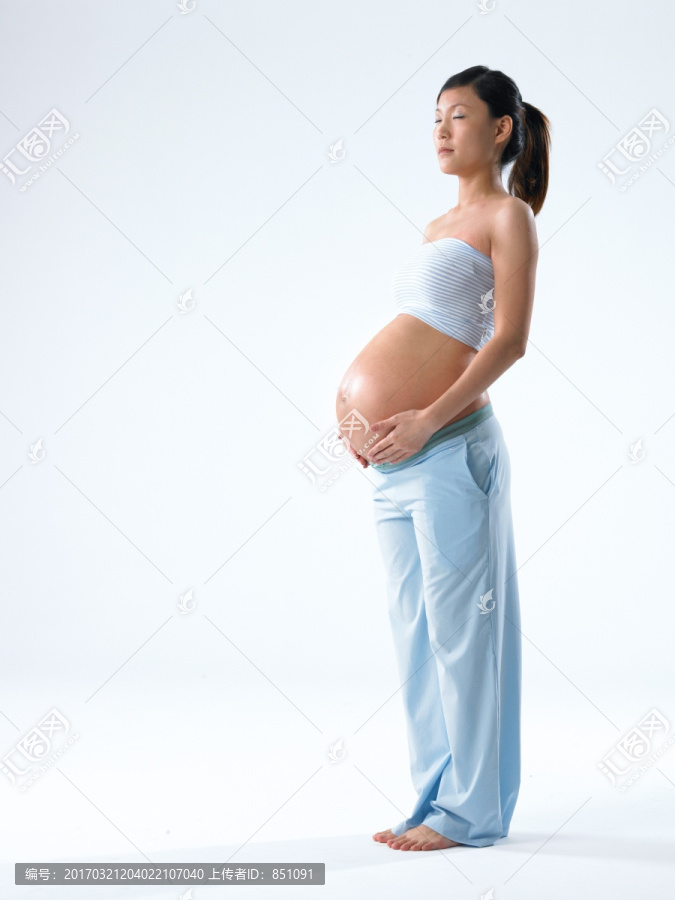 双手放在肚子上的孕妇