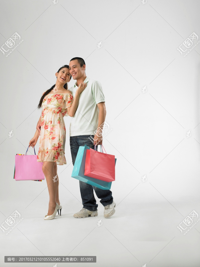 微笑着拎着购物袋的男女