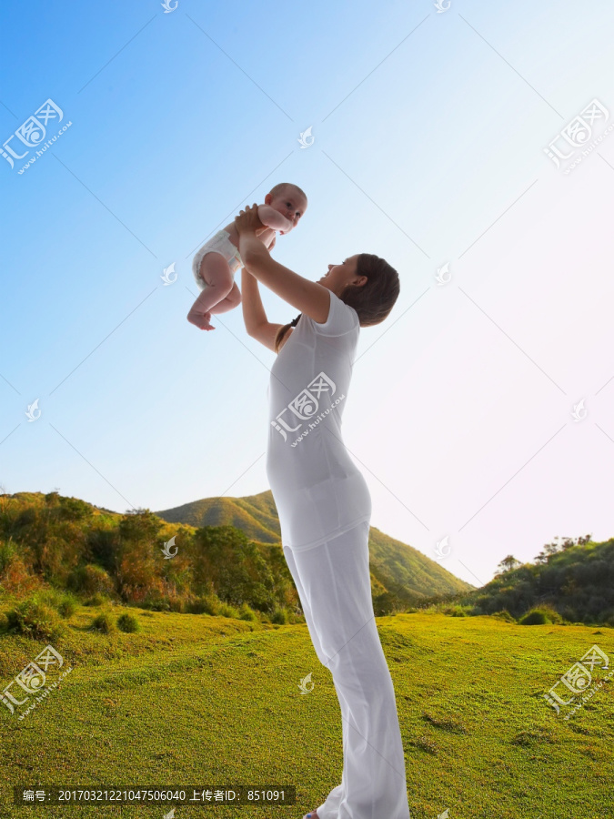 在户外抱起婴儿的母亲