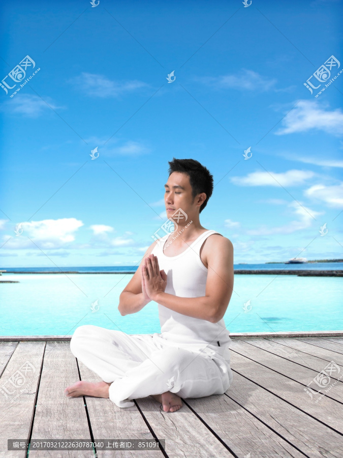 盘腿坐着练瑜伽的男人