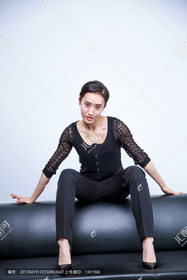 商务女士坐在黑皮沙发上