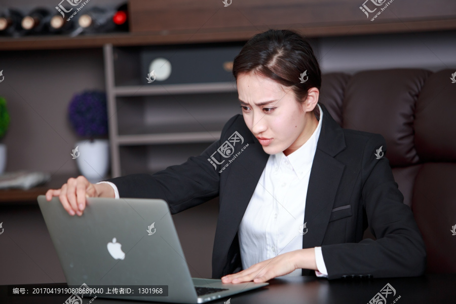 忧虑的女办公人士看着笔记本电脑
