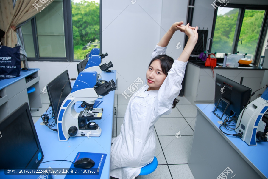 坐在实验室里伸懒腰的女学生