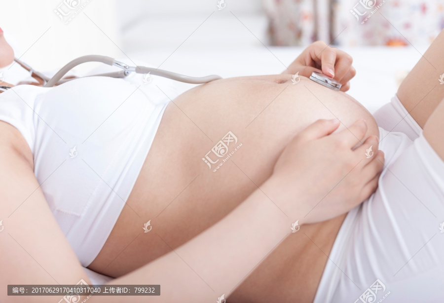 孕妇戴听诊器听胎儿声音