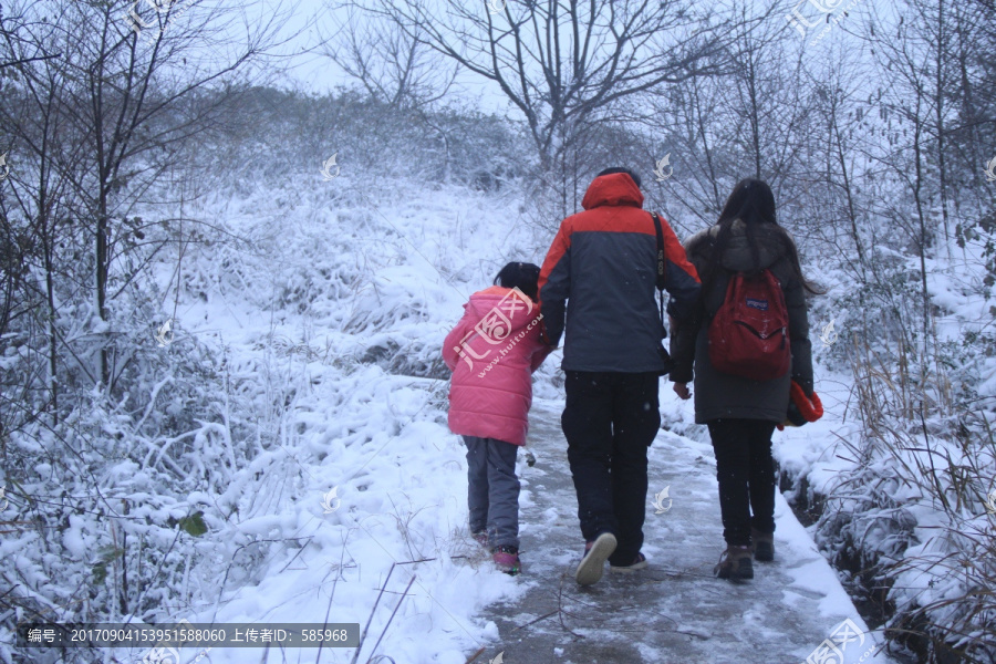 一家三口牵手在雪中散步