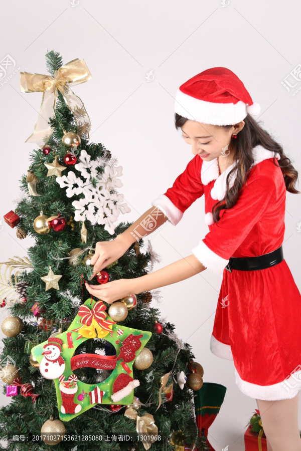 在装饰圣诞树的年轻女人