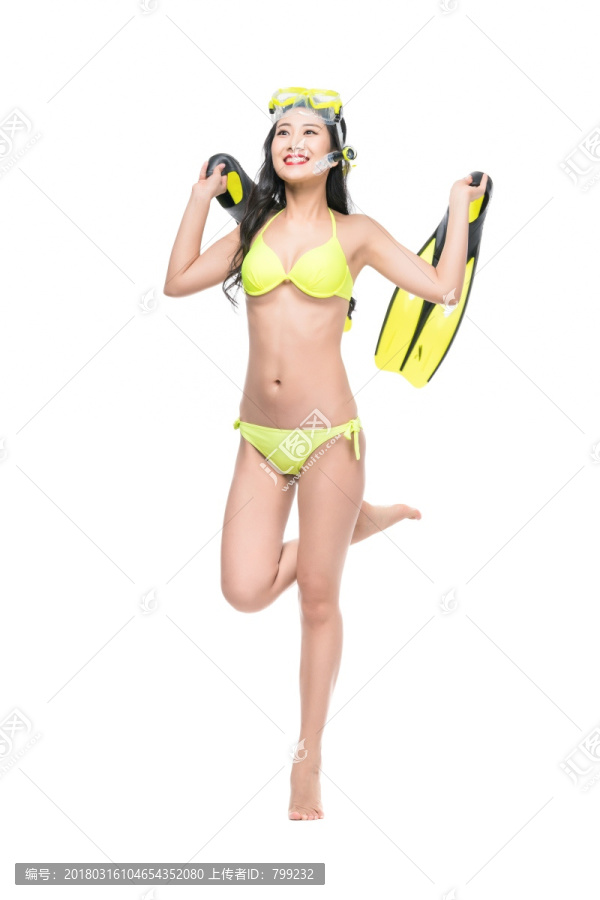 身穿黄色比基尼的年轻女子拿着潜水装备