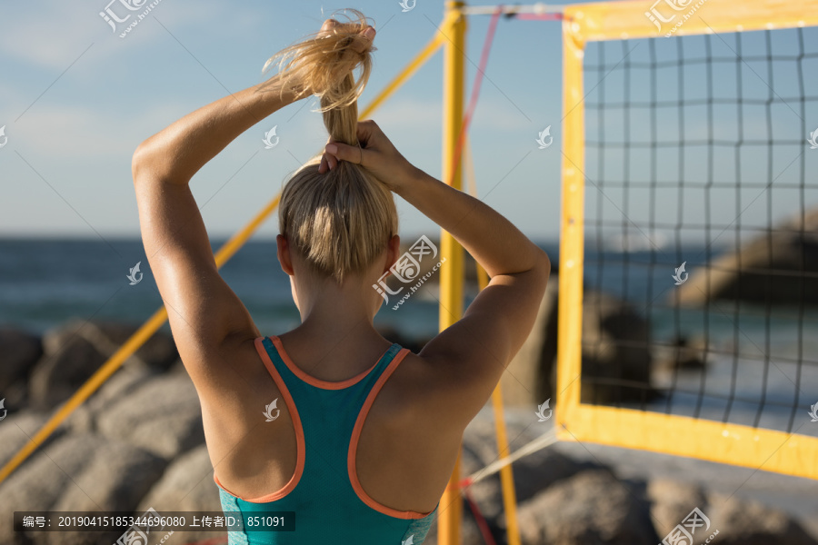 女排球运动员在沙滩上调整头发