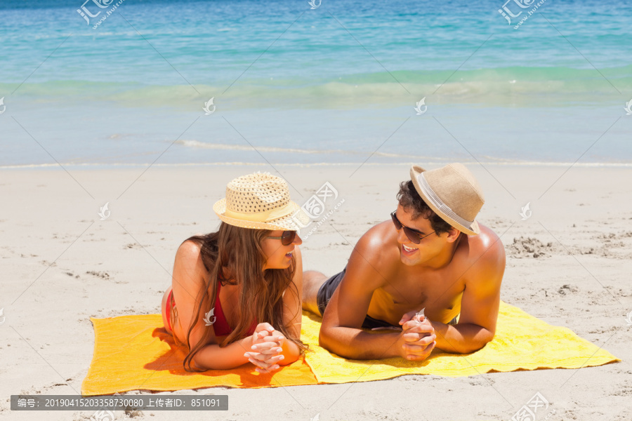 在沙滩上躺在晒日光浴的一对夫妇