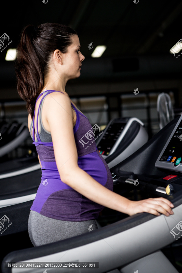 在健身房跑步机上的孕妇
