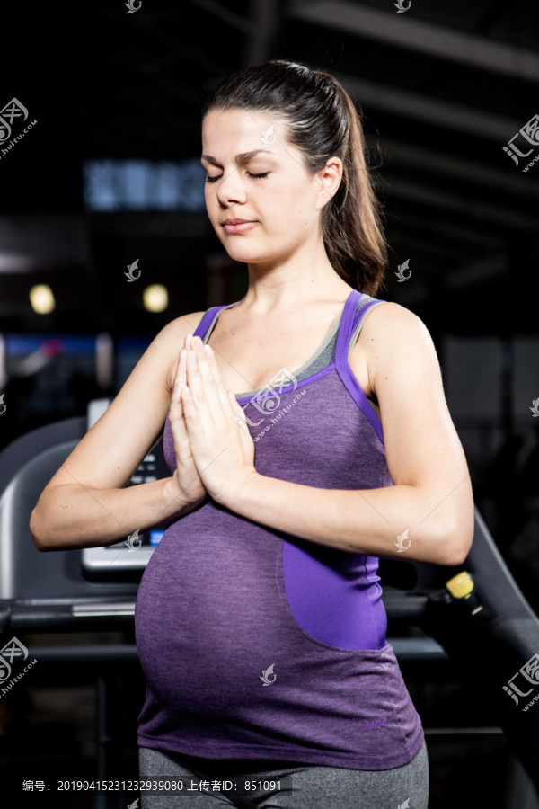 平静的孕妇在健身房做瑜伽