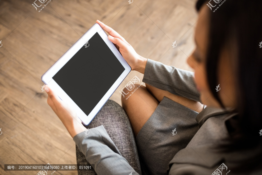 女商人在沙发上用平板电脑
