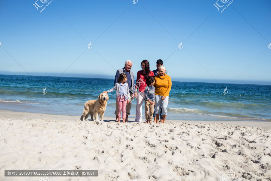 可爱的一家人在海滩上散步