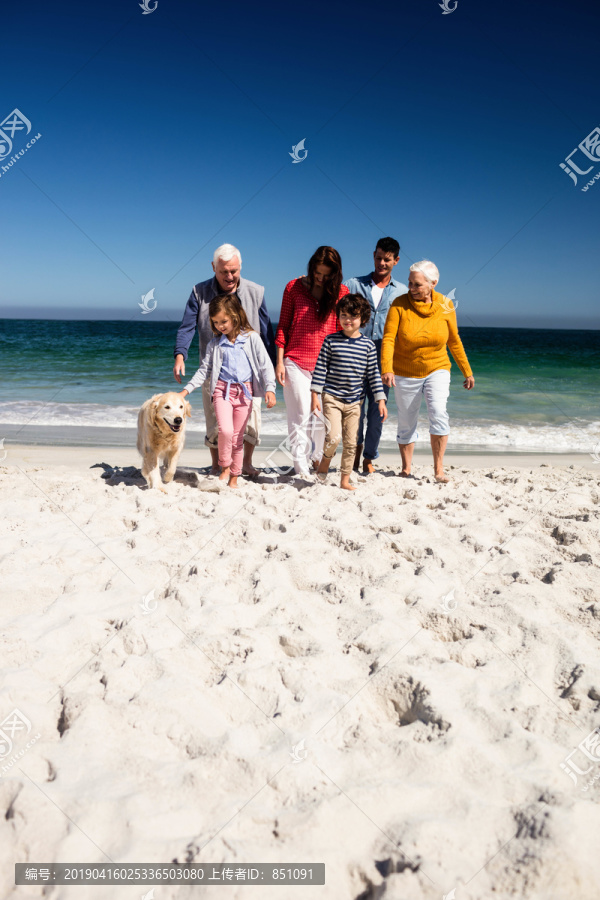可爱的一家人在海滩上散步