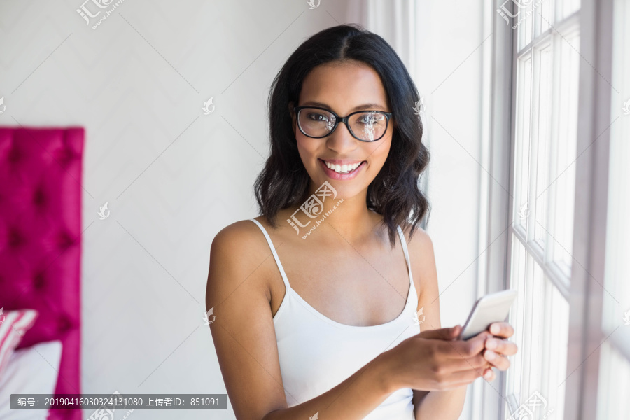 用智能手机微笑着的黑发女人