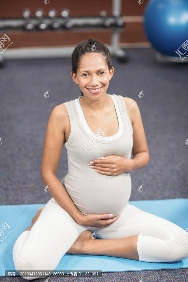 孕妇坐在休闲中心的运动垫上