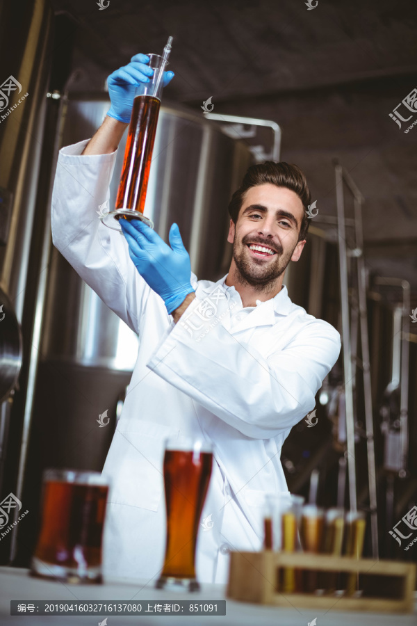 酿酒师在当地酿酒厂检查啤酒杯