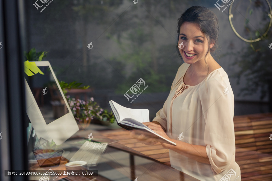 女商人在桌上读笔记本