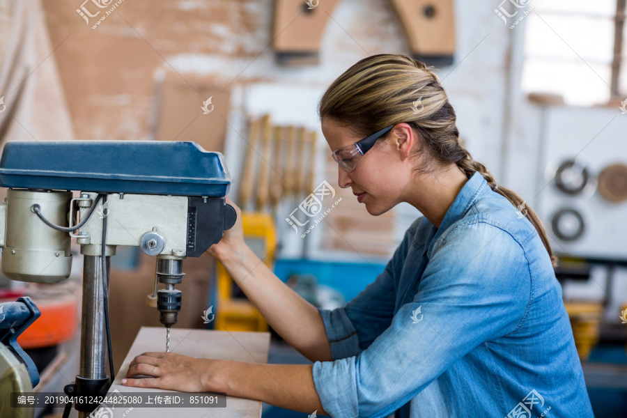 女木匠在木板上钻孔